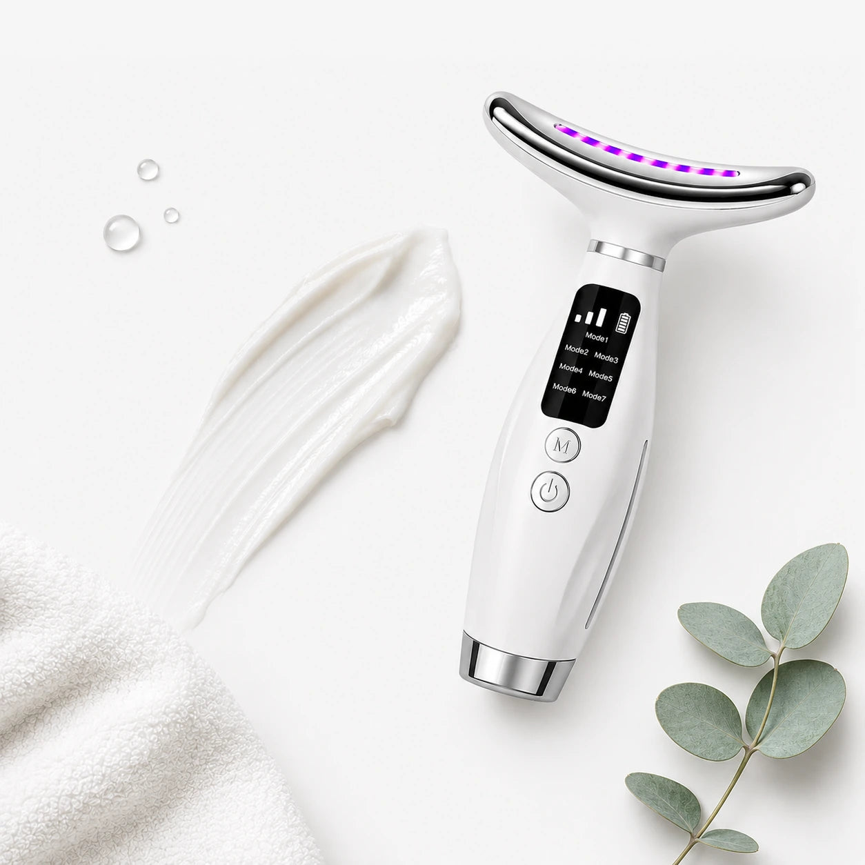 Face Lifting Device beside a swipe of cream and a eucalyptus sprig