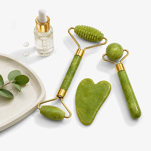 Gua Sha Jade — zestaw z jadeitu obok serum i gałązki eukaliptusa