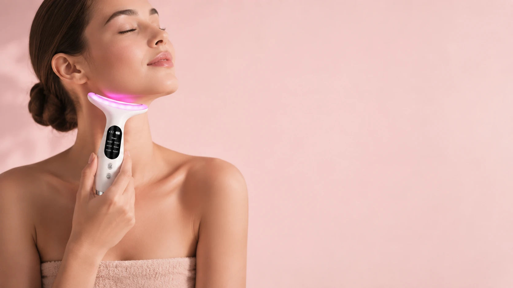 Woman treating her neck with the LED massager, red light glowing against her skin